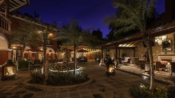 Relax in a serene courtyard surrounded by lush greenery and a central fountain.