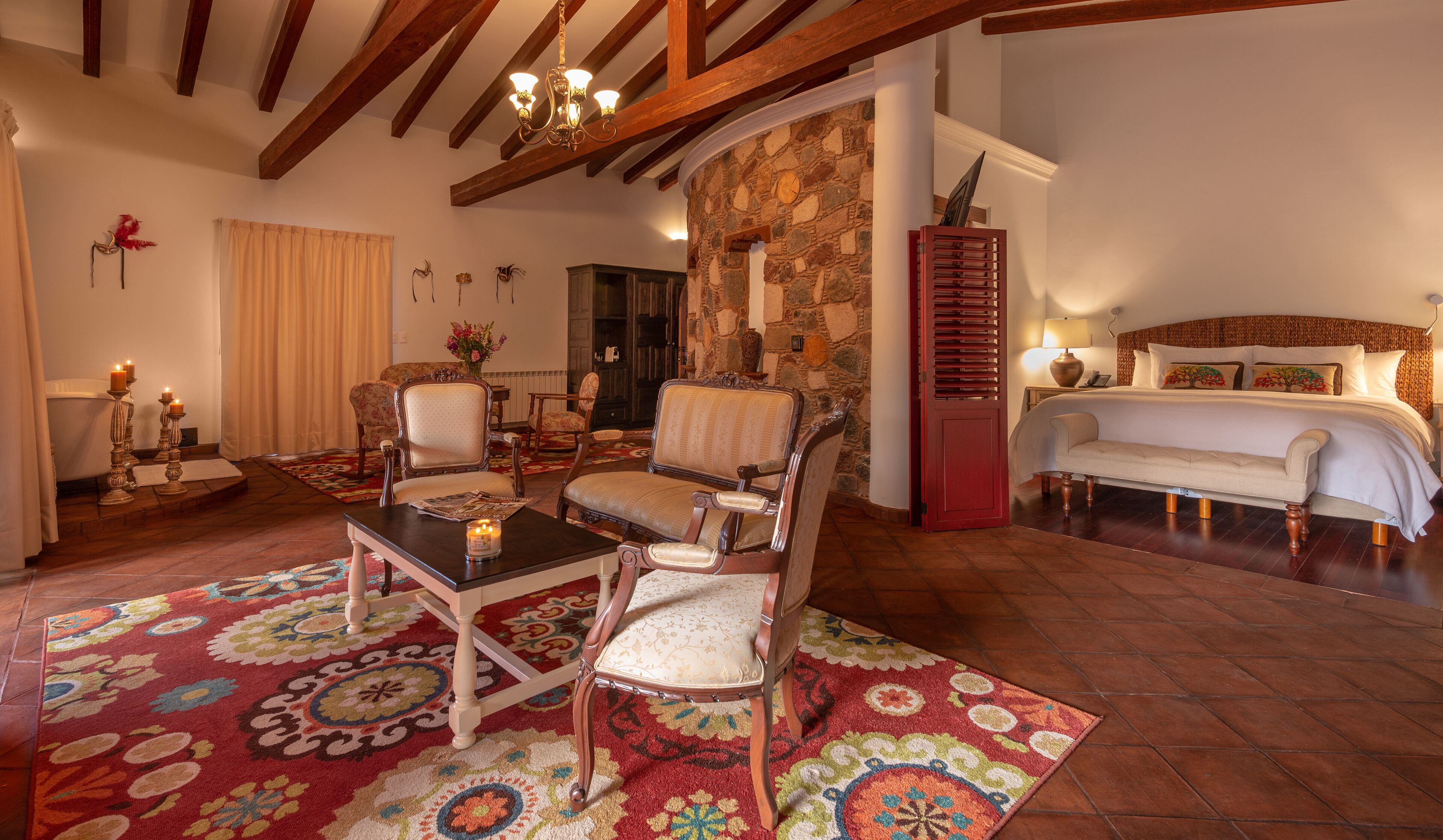 Una habitación acogedora con chimenea, una cama y una zona de comedor con sillas y una mesa.