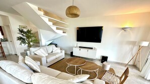 Ein modernes Wohnzimmer mit einer Couch, einem Couchtisch und einer Treppe.