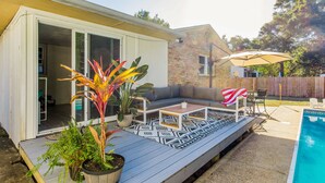 A covered patio with a pool, outdoor seating, and potted plants. - NAS, Pensacola Beach, Pool House -20mins to both beaches (Pensacola)
