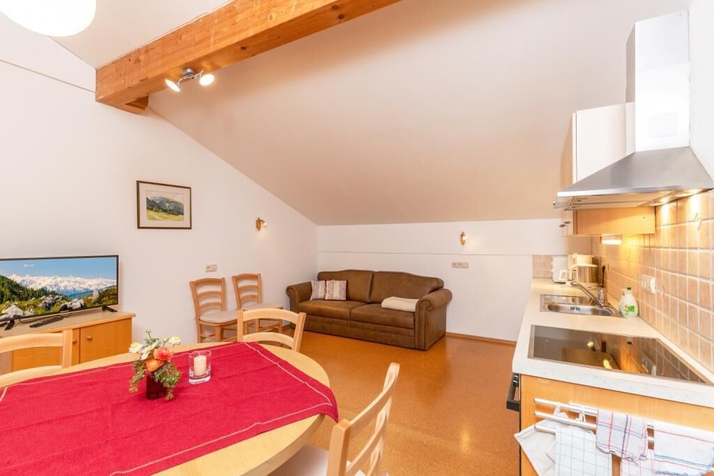 Un espace de vie compact comprenant un coin repas, une kitchenette et un canapé.