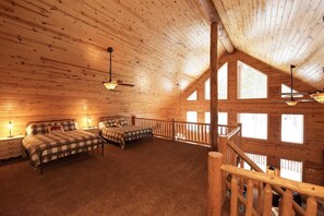 Cozy bedroom with sloped ceiling, exposed beams, and large windows.