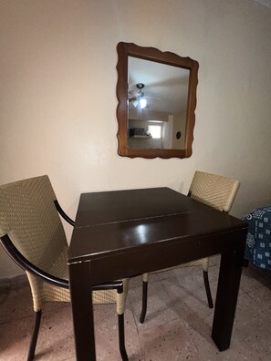 A dining table with four chairs, a wooden-framed mirror above it, and a tiled floor. - Villas Velarde + Pool + Great Location (cozumel)