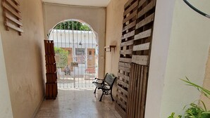 A corridor with a tiled floor, a bench, a gate, and a potted plant. - Villas Velarde + Pool + Great Location (cozumel)