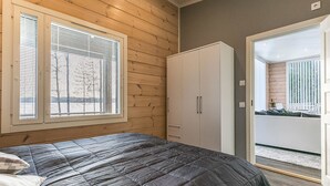 A bedroom with a bed, a wardrobe, and a sliding glass door leading to a balcony. - Metsola by Interhome (Ruovesi)