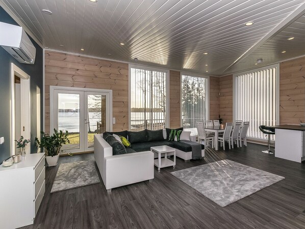 A modern living room with a sofa, coffee table, and dining area with chairs.