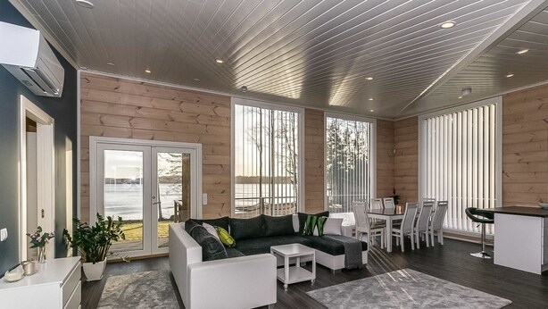 A spacious living area with a sofa, coffee table, and dining table. There is a large window providing a view of the outdoors. - Metsola by Interhome (Ruovesi)