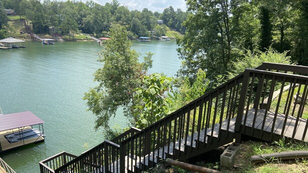 A wooden staircase leading down to a dock with boats, surrounded by greenery and a lake. - Discover Your Convenient Paradise: Minutes from I-65, Cullman, and Boat Launch (Cullman)