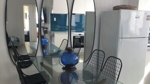 Ein Esstisch mit sechs Stühlen, einer blauen Dekorationsschale und drei Spiegeln an der Wand.