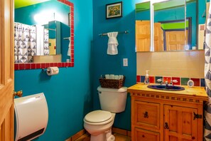 A bathroom with a toilet, a sink with a mirror, and a towel rack. - Chucks cabin Joshua Tree region, your desert Oasis (TWENTYNIN PLAMs)