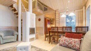 A cozy living room with a staircase, a dining area, and a kitchen.