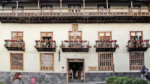 Un edificio tradicional con varios balcones decorados con plantas en macetas.