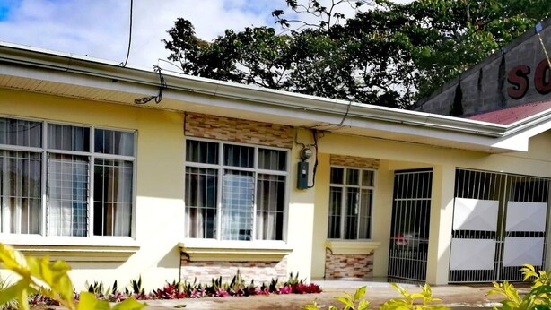 A two-story building with a yellow facade, multiple windows, and a gated entrance. - ARCO House, La Marina. Saint Charles (San Carlos)
