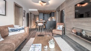 A modern living room with a wooden floor, a sofa, a coffee table, and a fireplace. - Winter Courchevel / Phoenix 502, proche commerce (Courchevel)