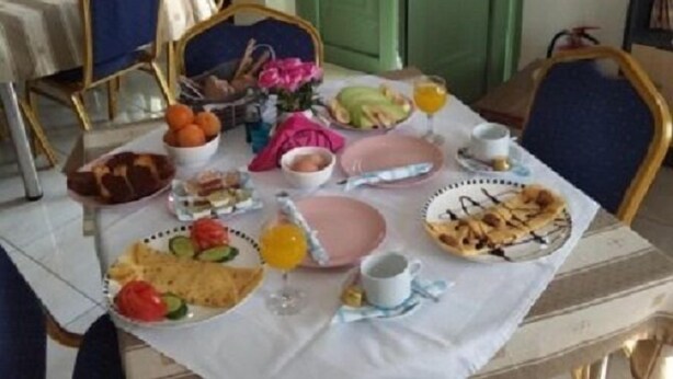 A dining table set with various breakfast items including fruits, bread, and beverages. - Pyrgos Sofokleous (Lesvos)