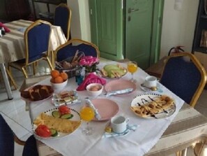 A dining table set with various breakfast items including fruits, bread, and beverages. - Pyrgos Sofokleous (Lesvos)