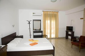 A hotel room with a bed, a desk, a chair, a TV, and a mirror. - Pyrgos Sofokleous (Lesvos)