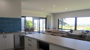 Una cocina moderna con una isla grande, lavavajillas y un comedor con vistas.