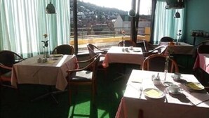Un restaurante con mesas dispuestas para comer, sillas y vistas al exterior.