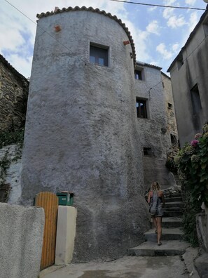 A rustic stone building with a small window and a door.