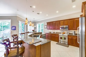 A modern kitchen with wooden cabinets, stainless steel appliances, and a central island.