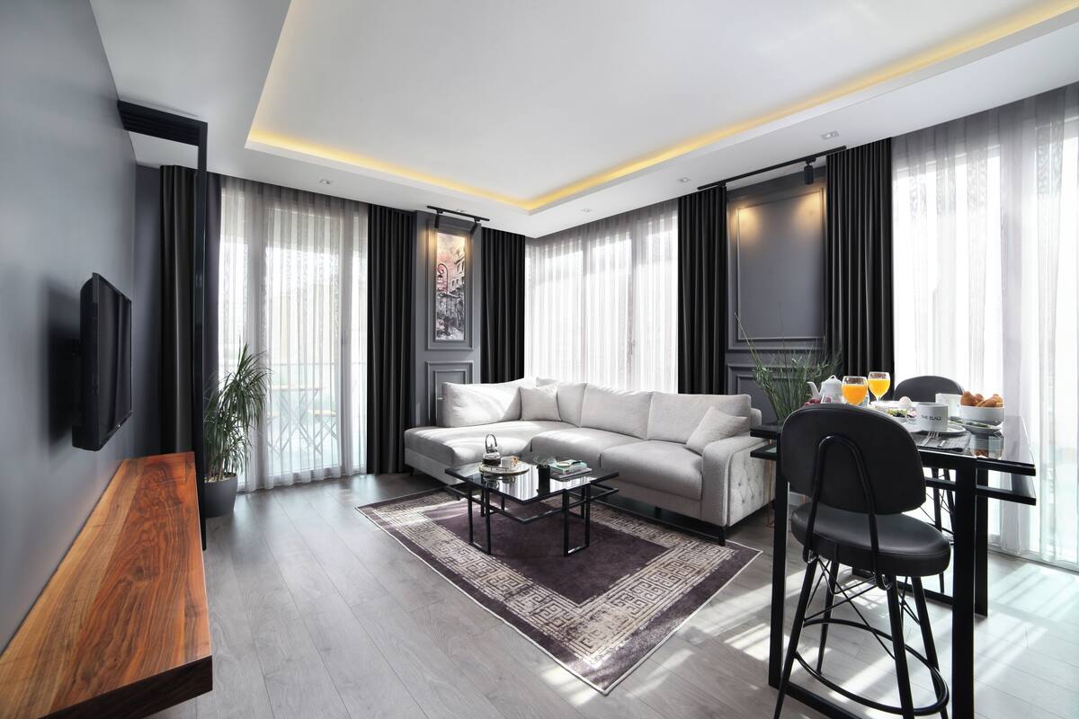 A modern living room with a sofa, a dining table, and a coffee table.