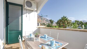 Ein Balkon mit Tisch, Stühlen und Blick auf die umliegende Landschaft.