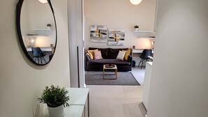 A modern living room with a sofa, coffee table, and artwork on the wall. - N&J - KORNER AVENUE TERRACE - Hyper center (Niza)