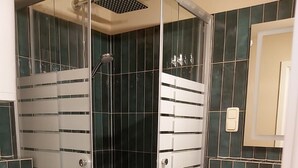 Un bagno moderno con doccia vetrata, lavandino bianco e water.