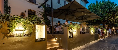 A cobblestone street leading to a building with a sign for 'Sarracino pizza & cucina'.