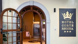 La entrada al Hotel Corte Regina, con un doble portal y un felpudo.