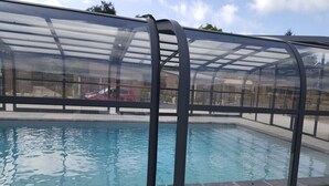 Une piscine dotée d’une enceinte en verre et d’une structure métallique.