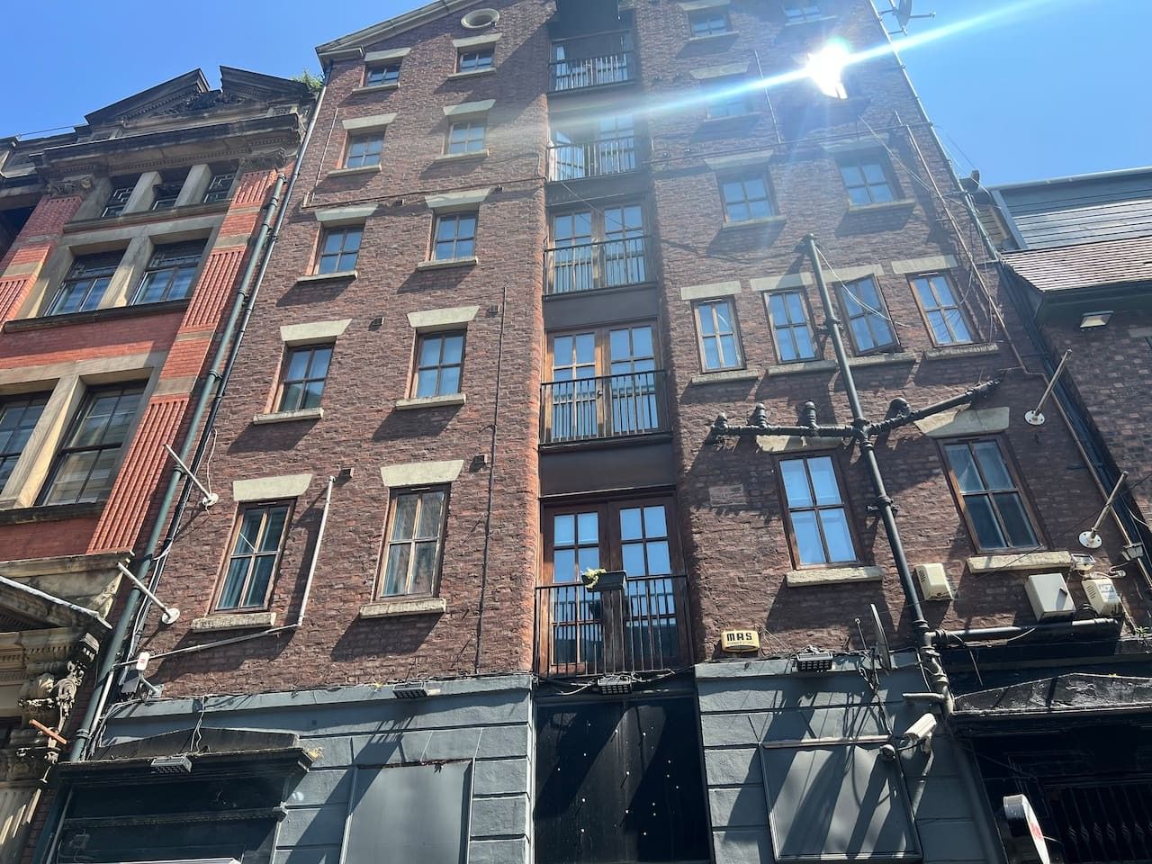 A multi-story brick building with multiple windows and balconies.