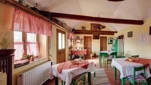 Un comedor acogedor con vigas de madera, un radiador y mantel a cuadros.