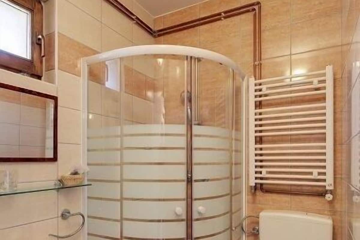 Une salle de bain avec une douche à parois de verre, des toilettes et un lavabo.