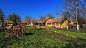 Entorno rural con edificios tradicionales, un área verde y una valla de madera.
