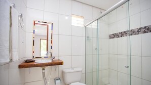Une salle de bain moderne avec une douche à parois de verre, un meuble-lavabo en bois et des toilettes blanches.