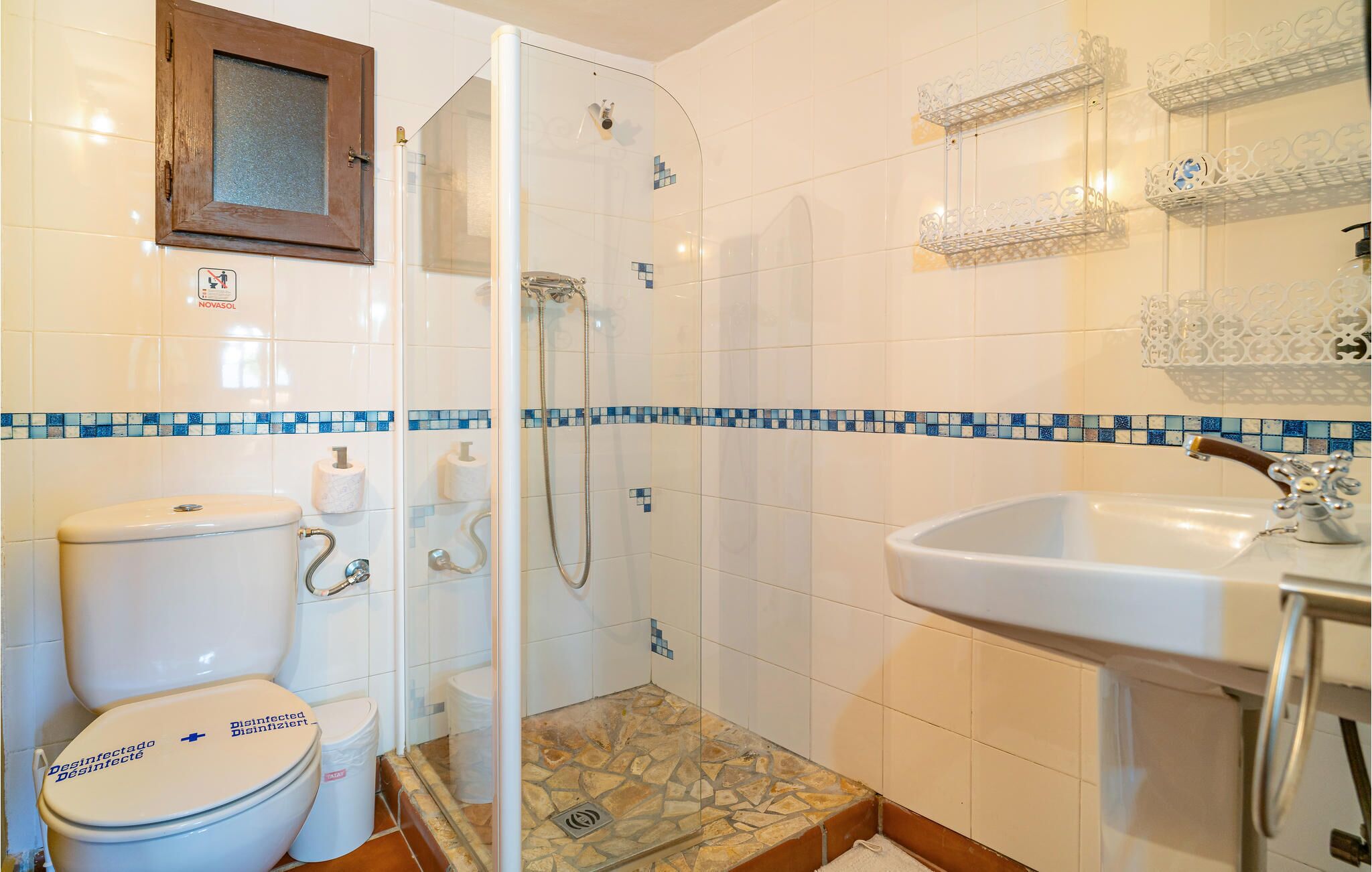 A bathroom with a toilet, shower, and sink.