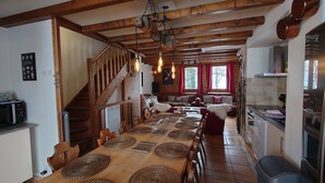 Una cocina acogedora con una mesa de madera, sillas y una escalera.