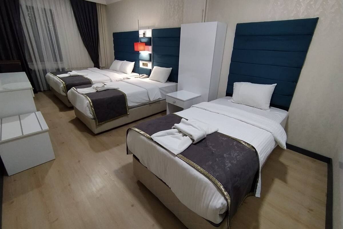A hotel room with two beds, a desk, and a chair.