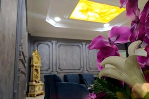 Ein Zimmer mit modernem Deckenstil, einer dekorativen goldenen Statue und einem blauen Sofa.