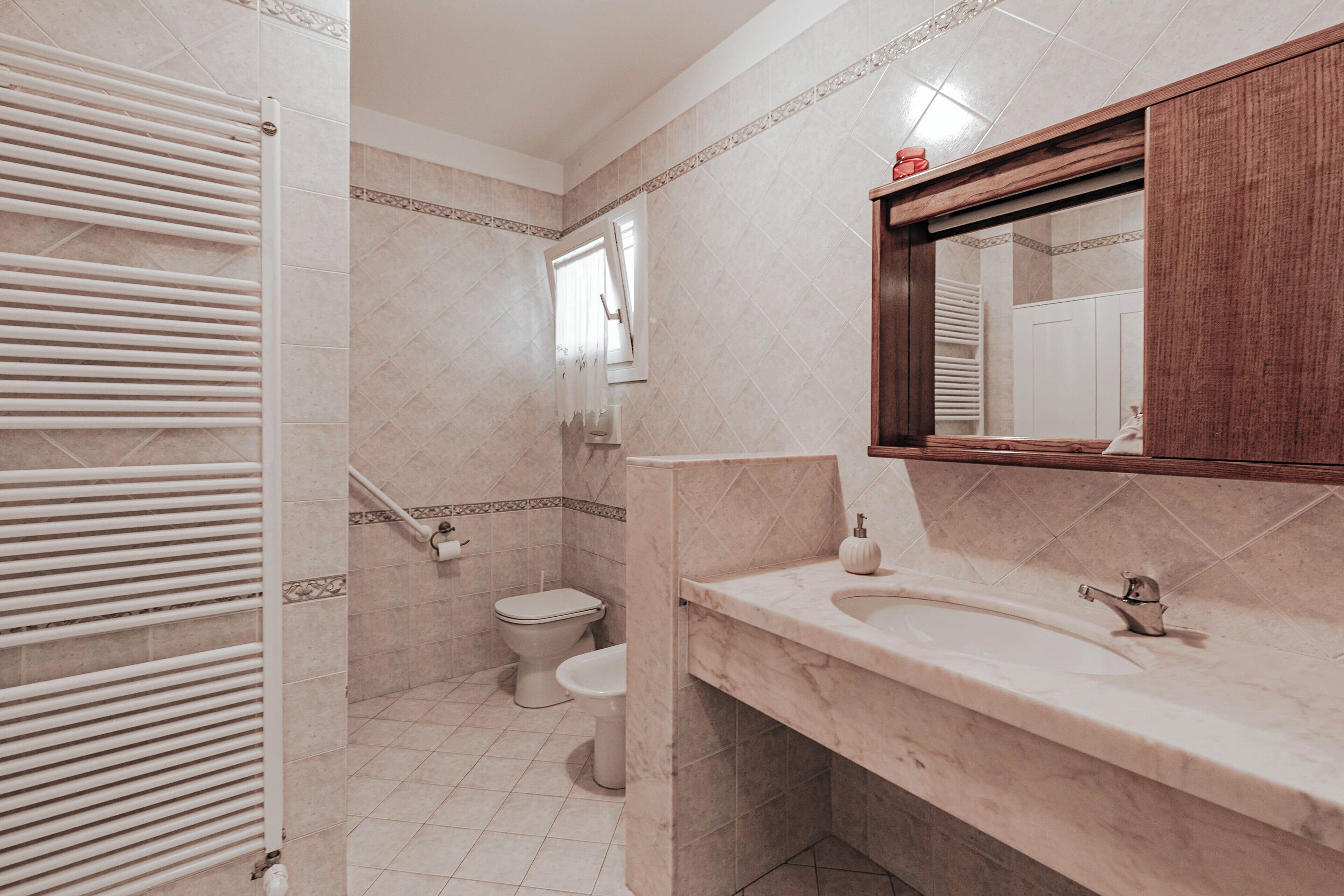 A bathroom with a white sink, a mirror, and a toilet.