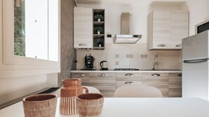 Une cuisine moderne avec des meubles en bois, un four encastré et une machine à café.