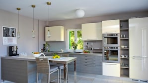 A modern kitchen with a central island, stainless steel appliances, and a view of greenery outside. - Beautiful home in Postira (Postira)