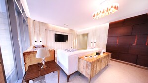 A modern hotel room with a large bed, a TV mounted on the wall, a wooden side table, and a large window. - EVA Hotel (Jeddah)