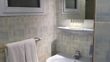 Une salle de bain avec un lavabo, un miroir et un porte-serviettes.
