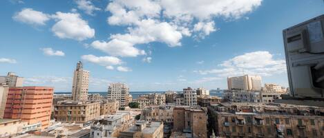 Uma área urbana densamente povoada com diversos estilos de construção, incluindo edifícios altos e baixos, sob um céu parcialmente nublado.