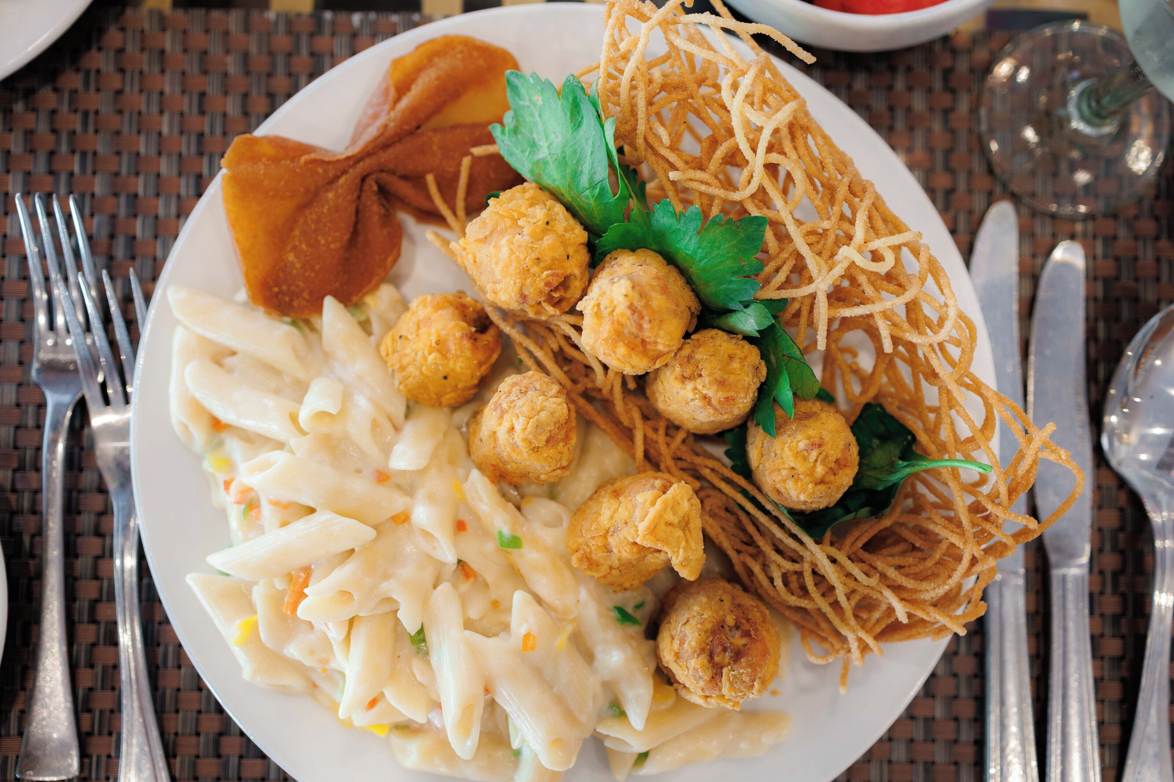 Prato com massa, bolinhos fritos e macarrão.
