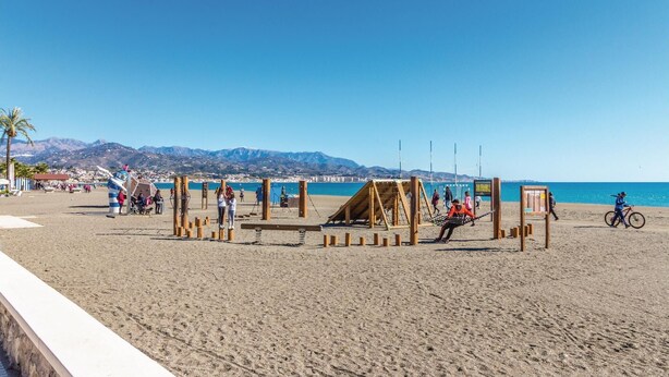 A beach with a volleyball net and wooden structures, a cyclist, and mountains in the background. - Lovely home in Periana (Periana)