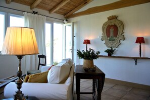 Cozy retreat with a traditional aesthetic, featuring a sofa, side table, and wooden shelf.